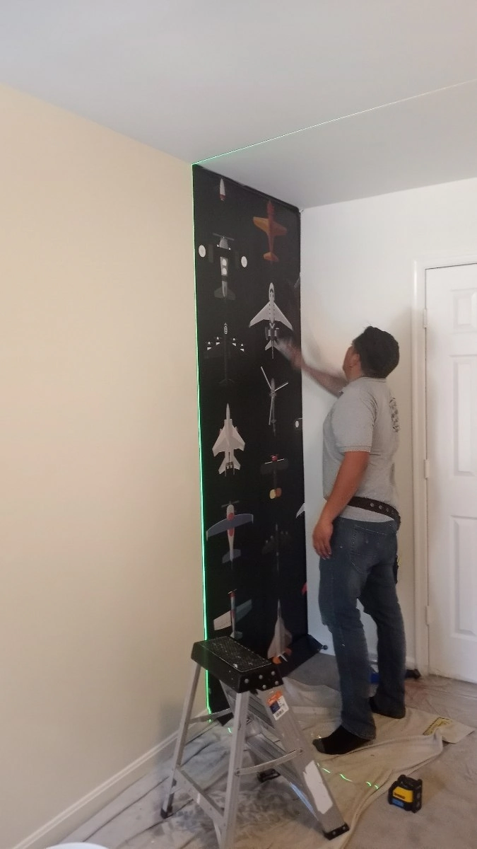 Detail specialist ensuring perfect wallpaper alignment around fixtures